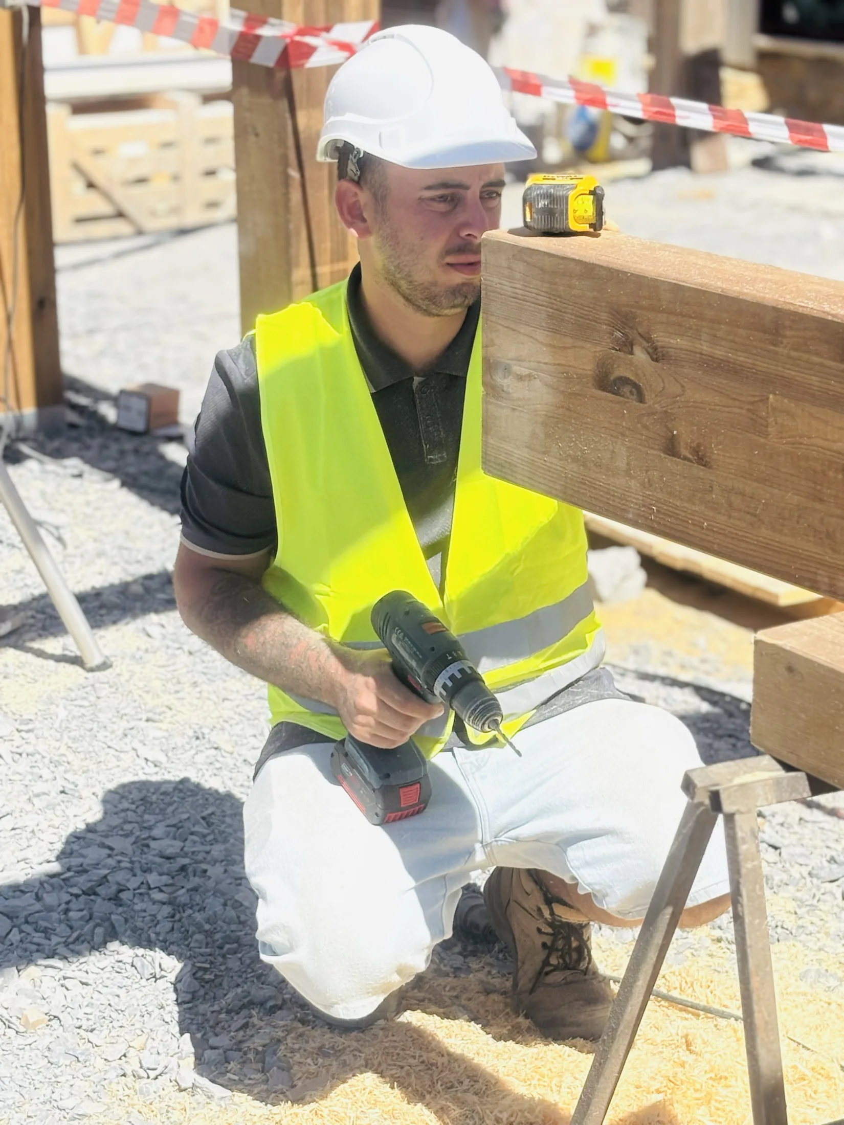 Guilherme a medir uma estrutura de madeira numa obra